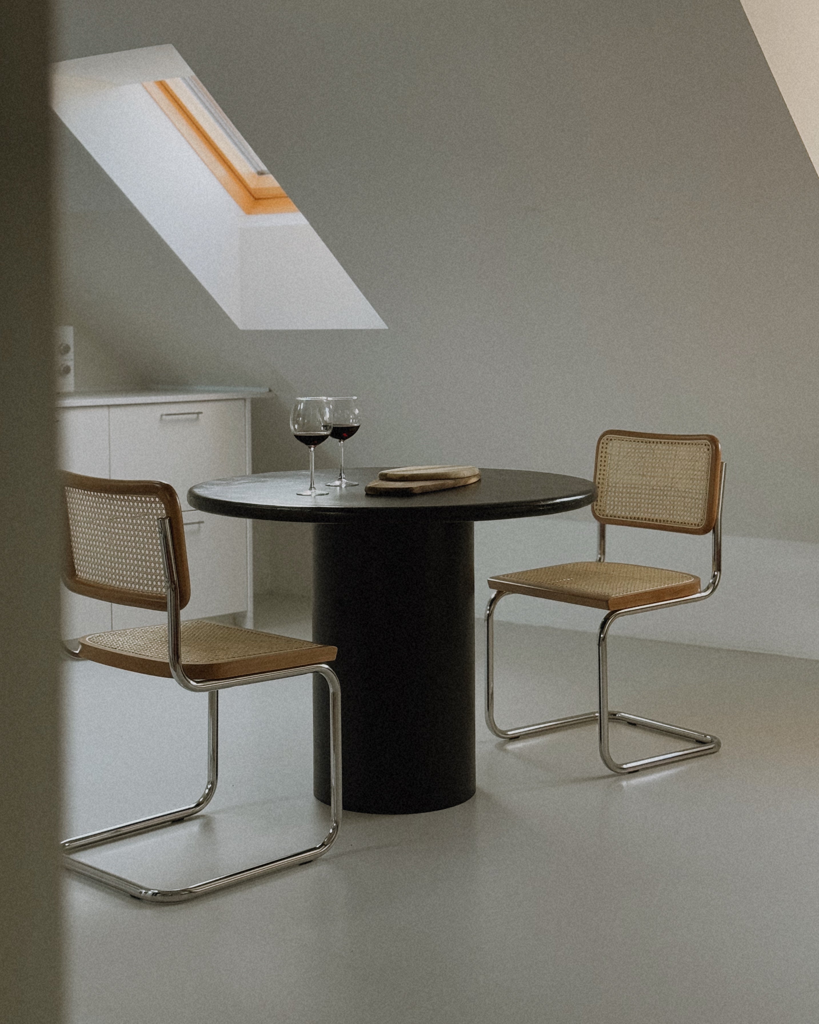 Side view of Kanso Round dining table with microcement surface and decoration