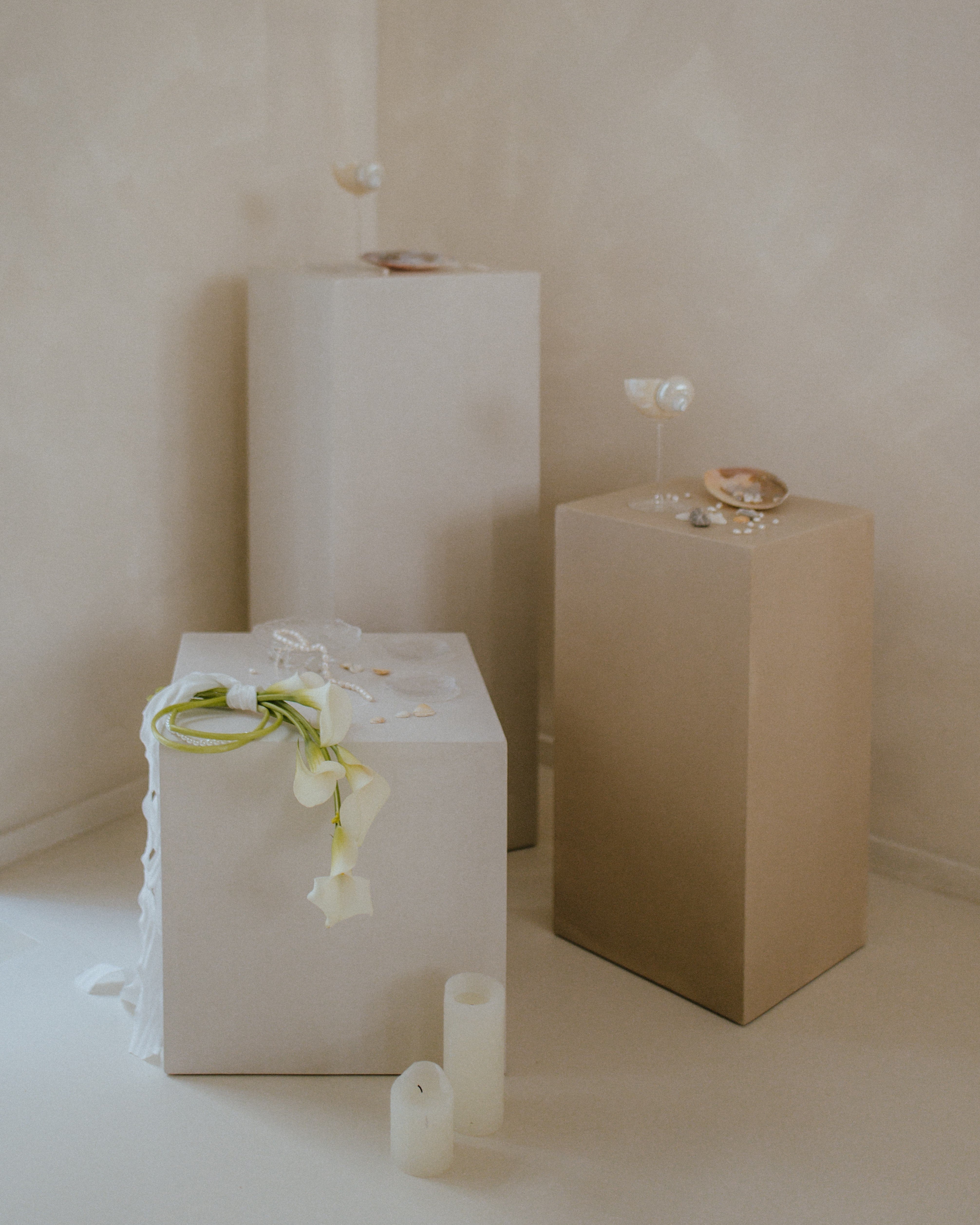 Two microcement pedestals in neutral beige, minimalist plinths styled with decor