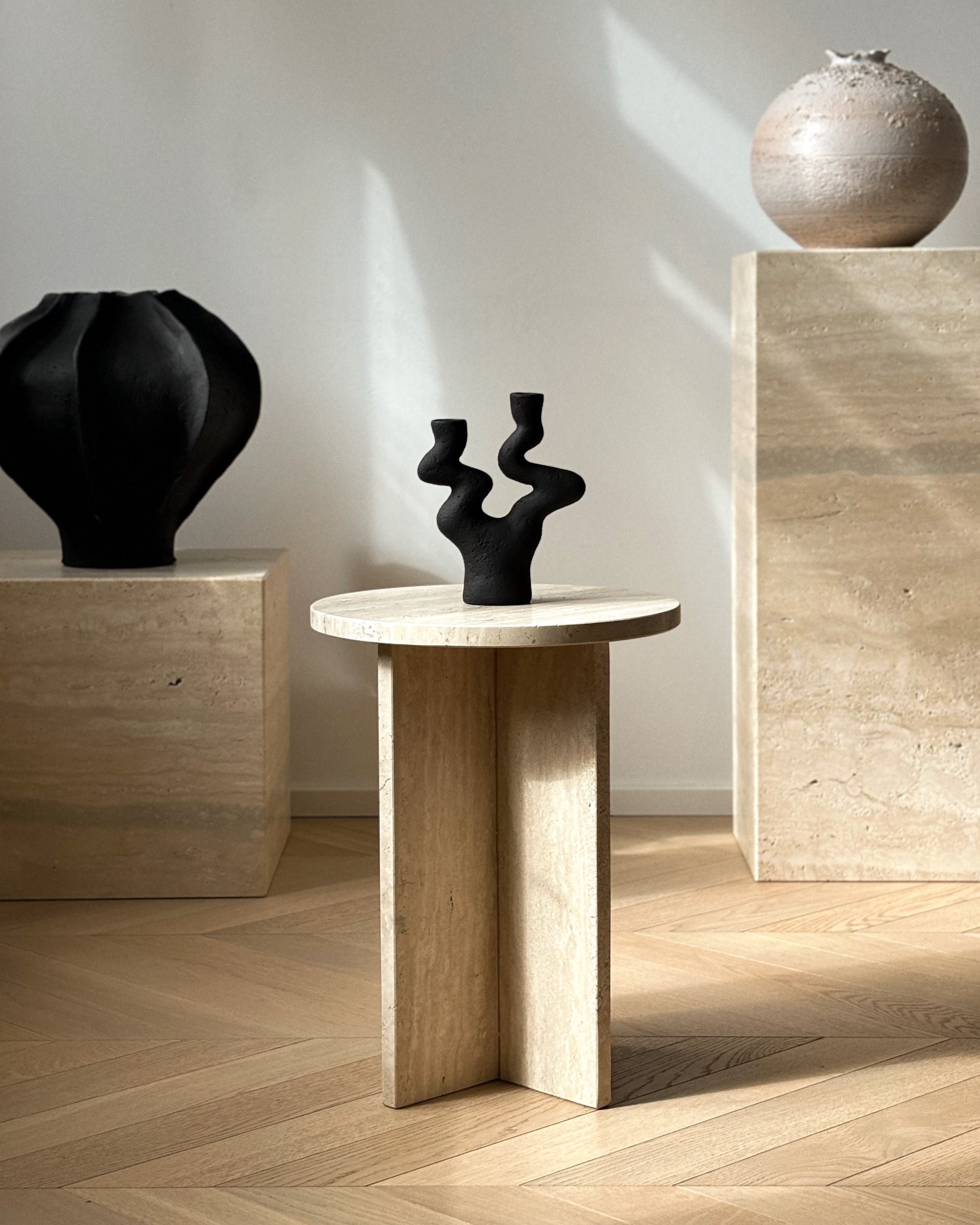 Round marble side table in Diano Reale stone, minimalist interior with chair