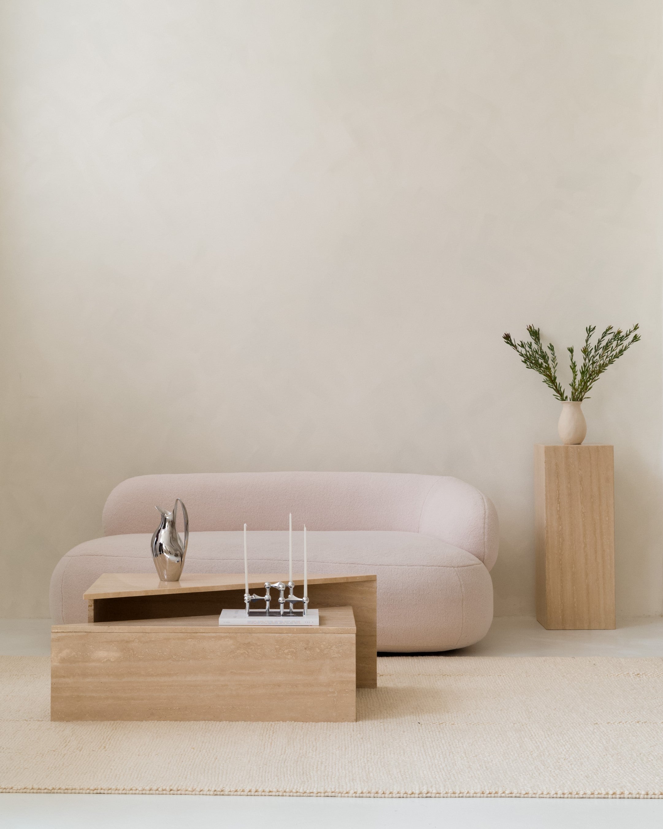 Set of two triangular travertine side tables, minimalist stone design with decor