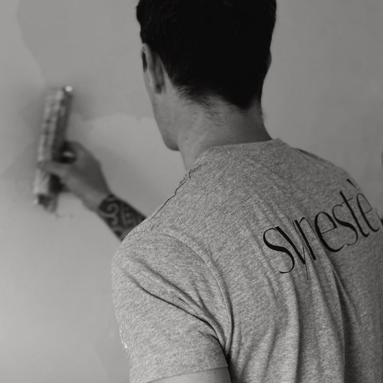 Syneste team applying microcement finish on a wall, professional craftsmanship in progress
