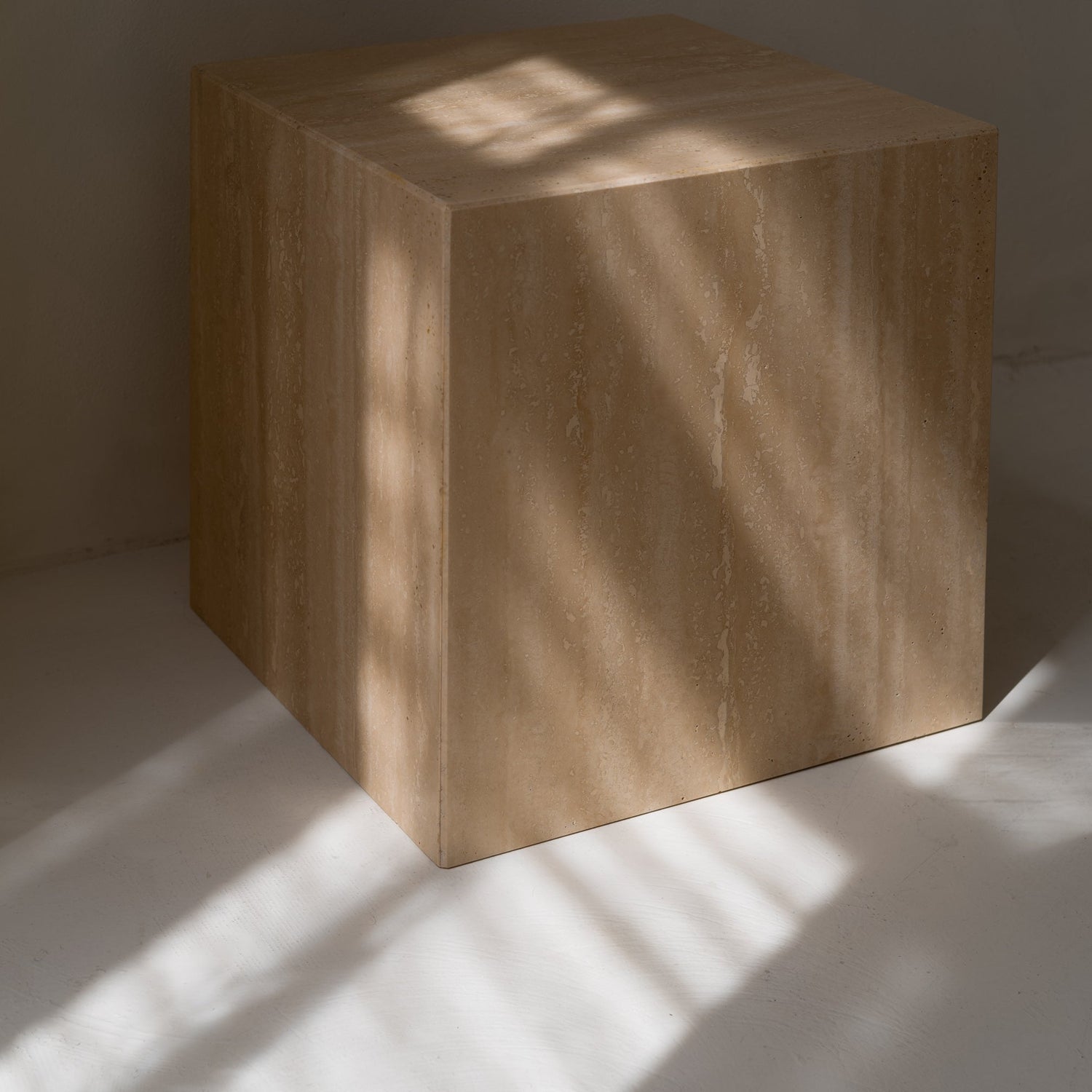 Traverine side table with geometric shape in soft sunlight