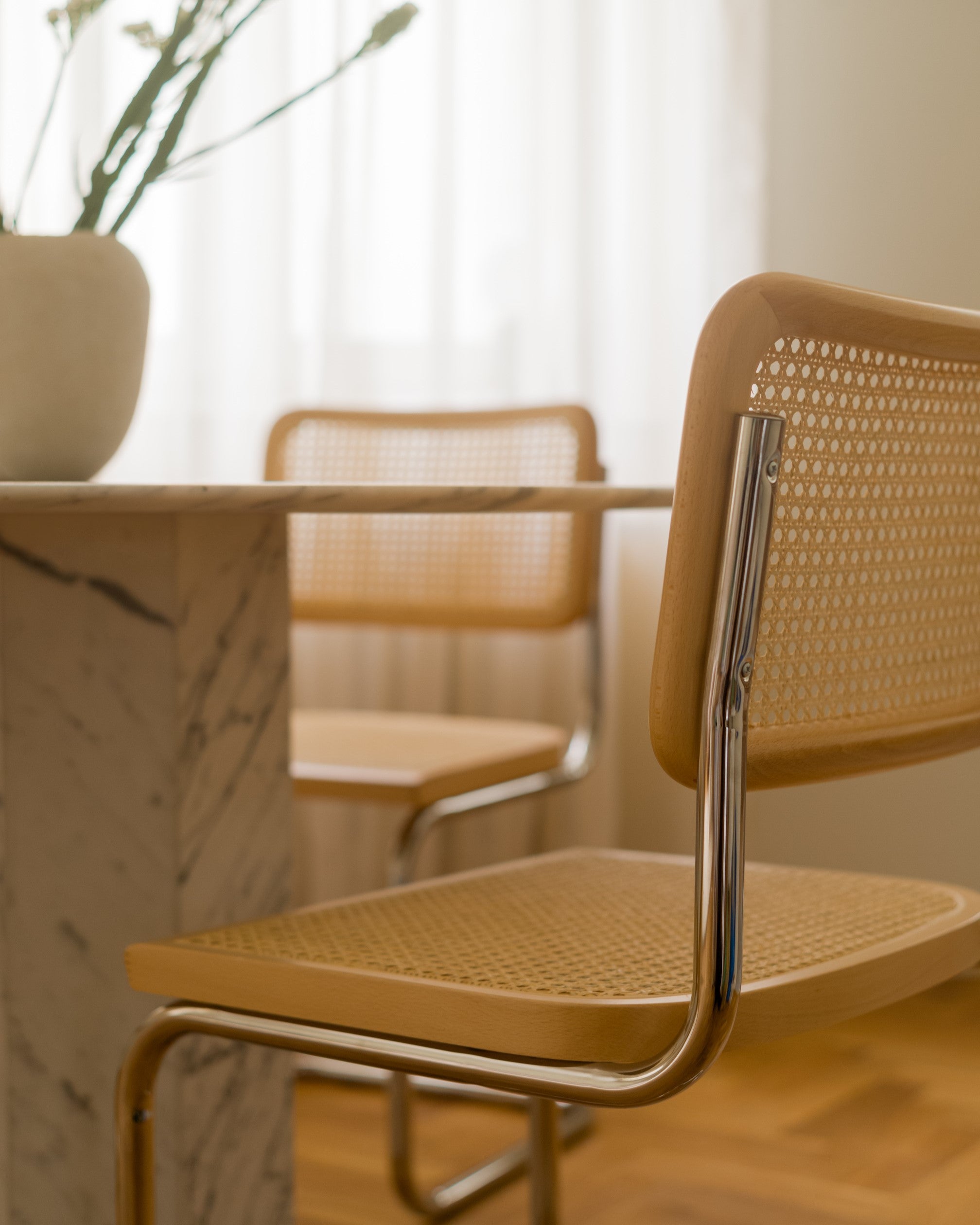 Cesca-inspired chair placed by a dining table in bright interior