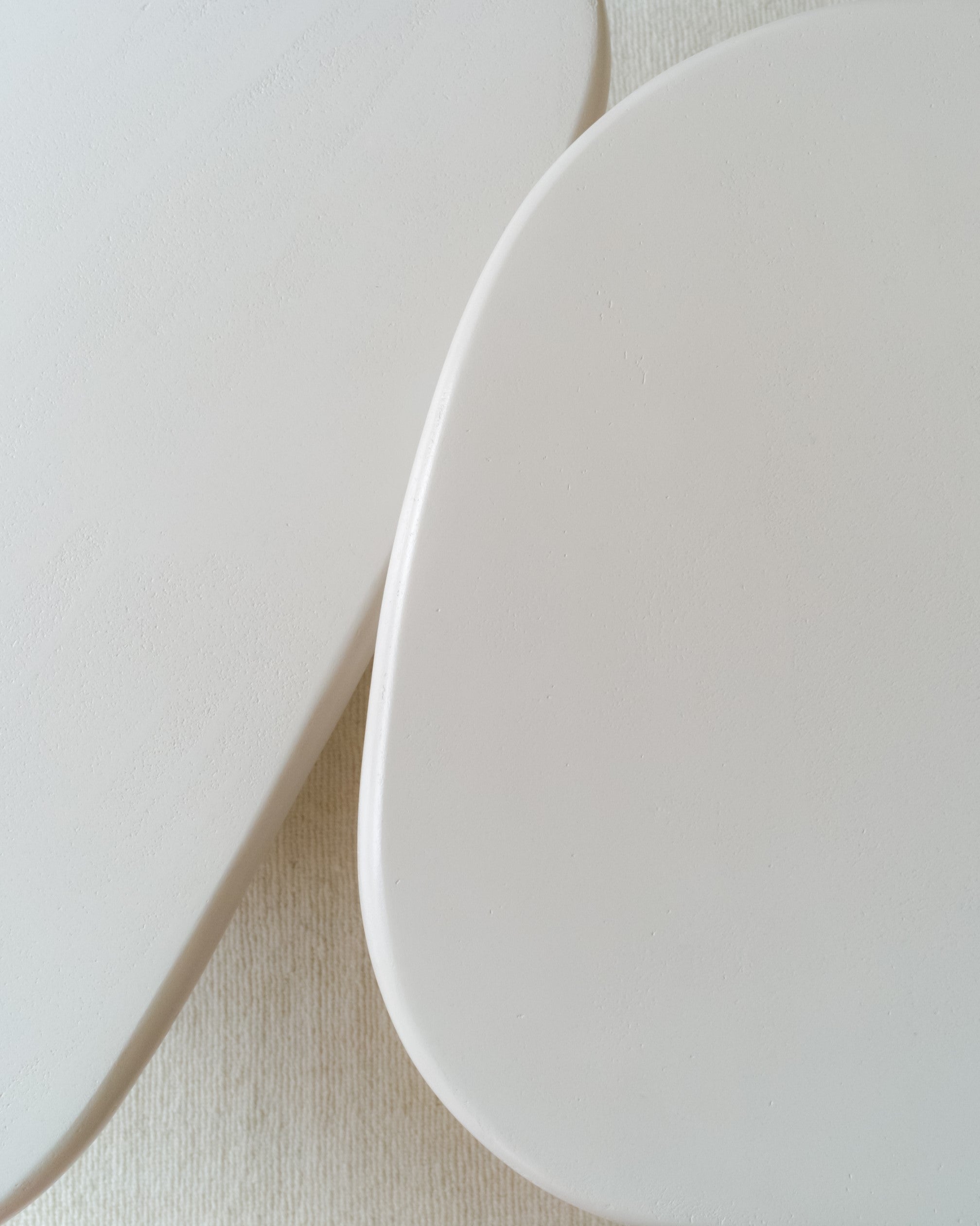 Close-up of asymmetrical microcement table tops with soft rounded edges