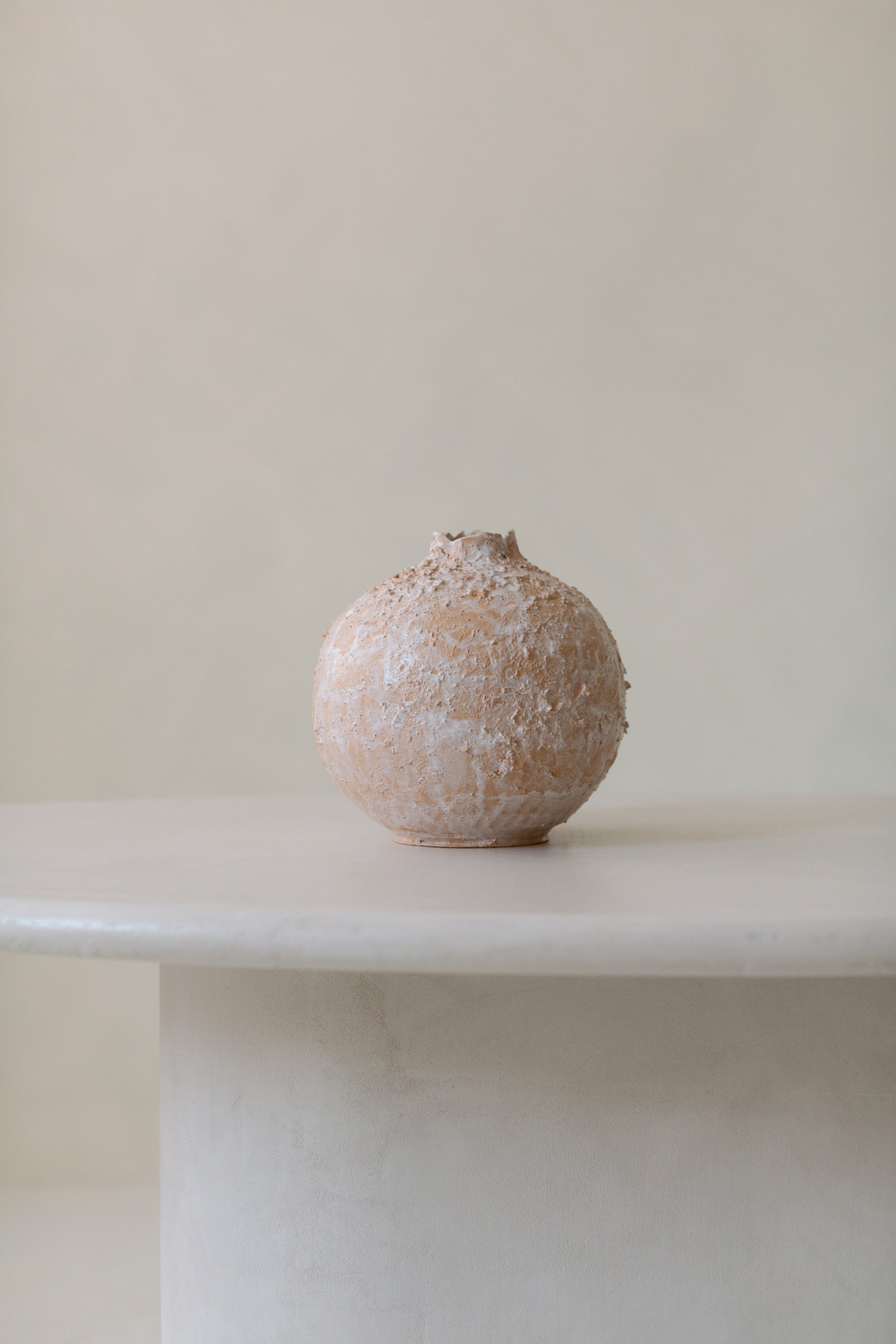 Kanso Ellipse microcement dining table styled with subtle minimal accessories