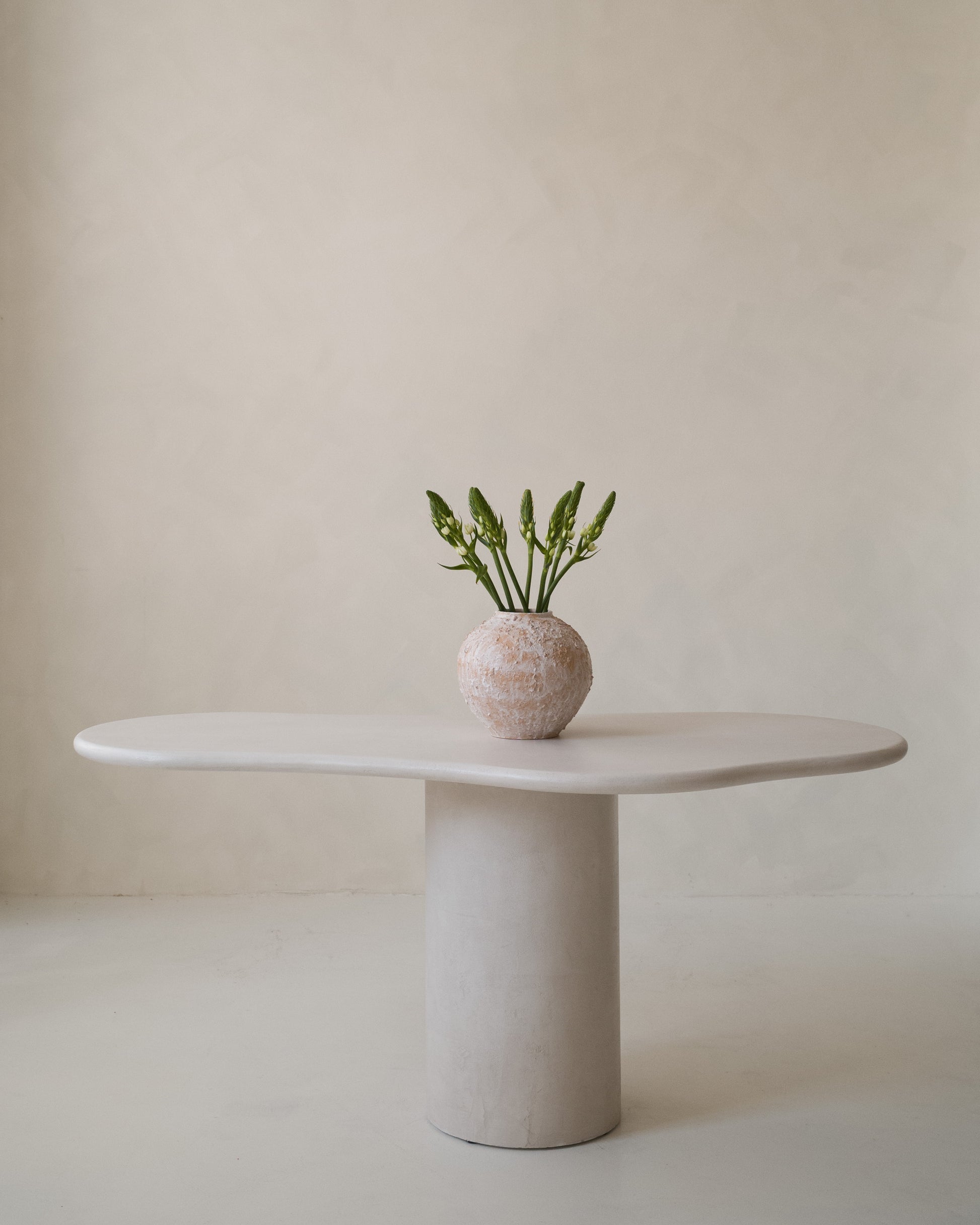 Close-up of Kanso Organic dining table styled with ceramic vase