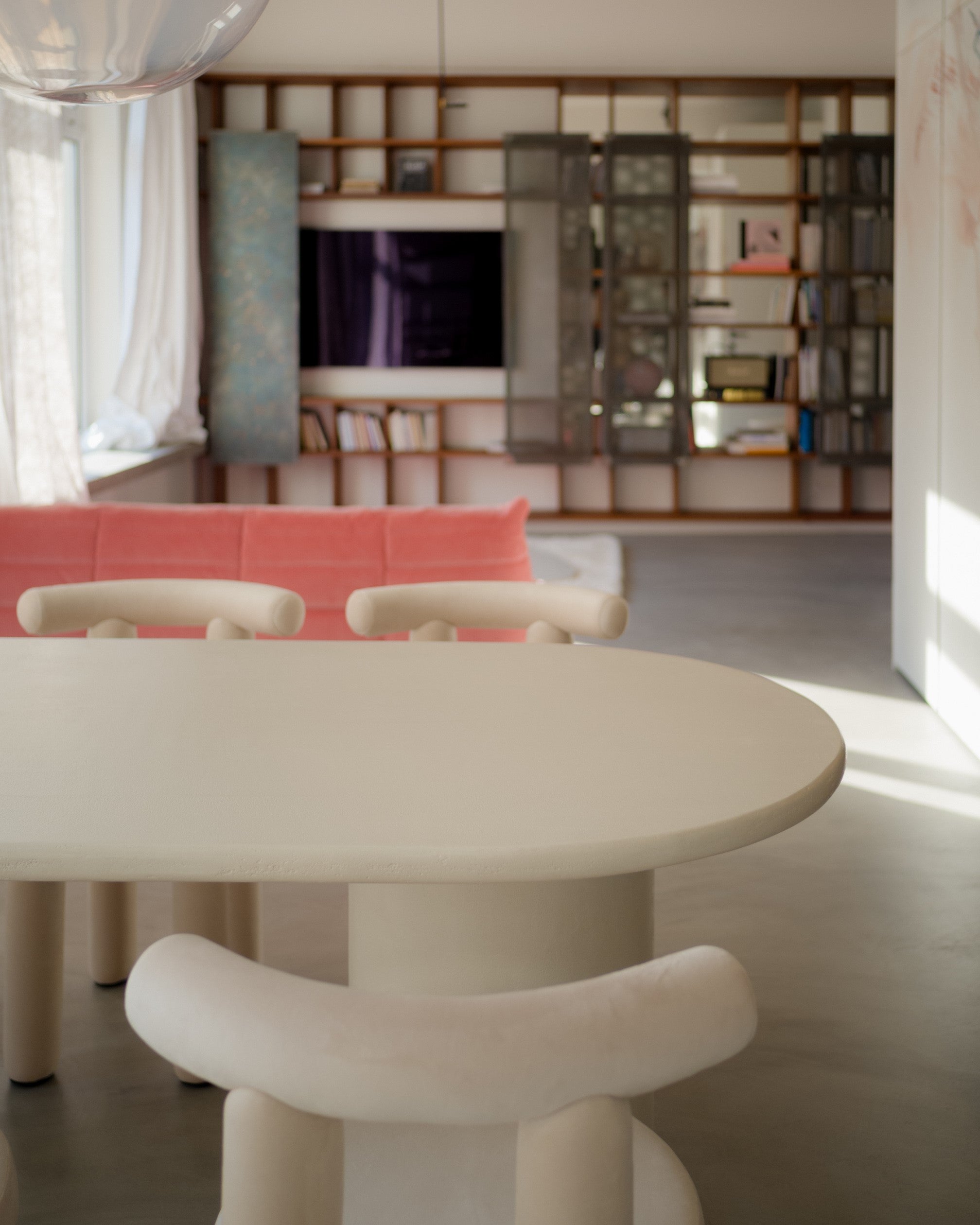 Kanso Oval microcement dining table styled for dining with glasses and plates