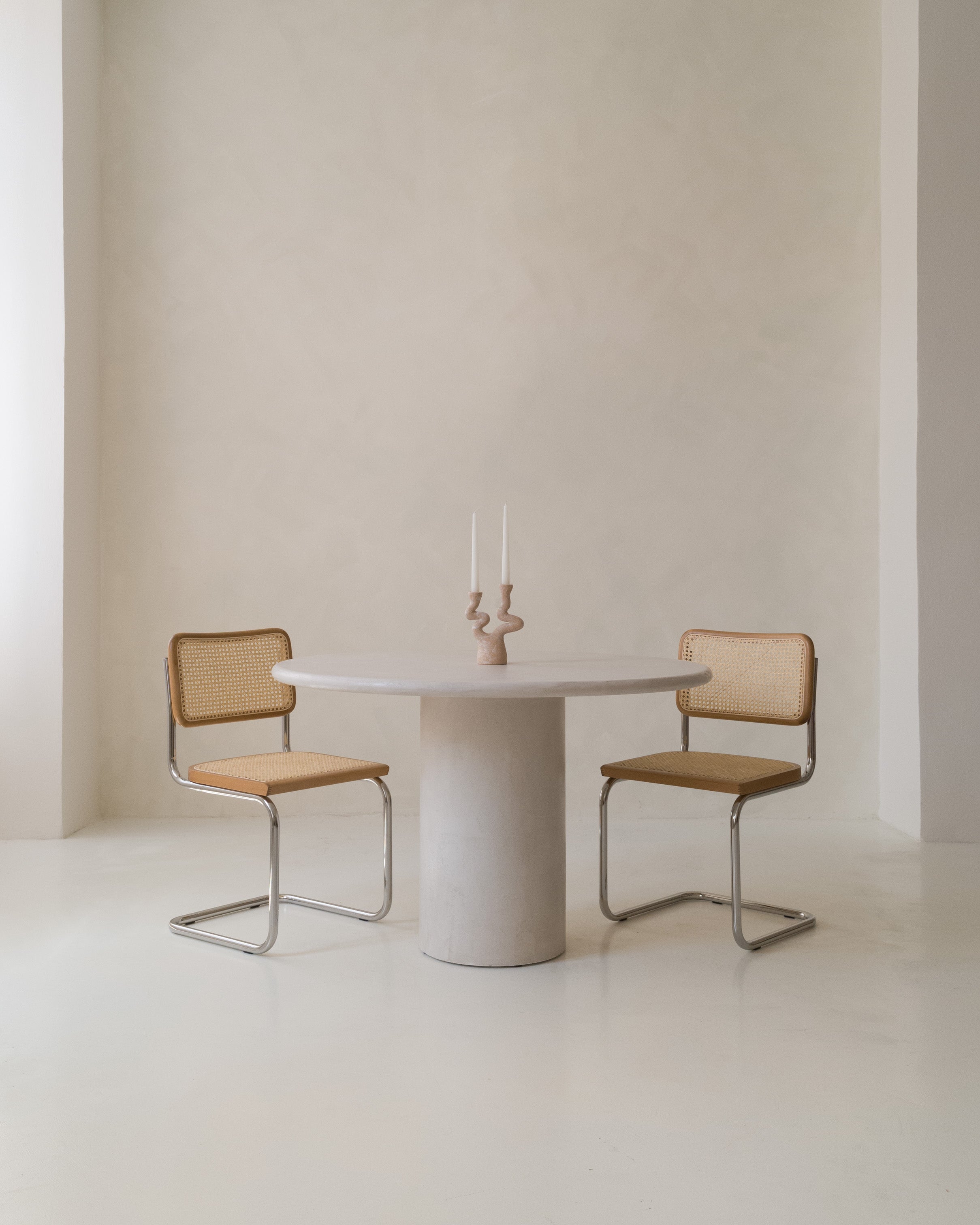 Minimalist interior with Kanso Round dining table in seamless microcement finish