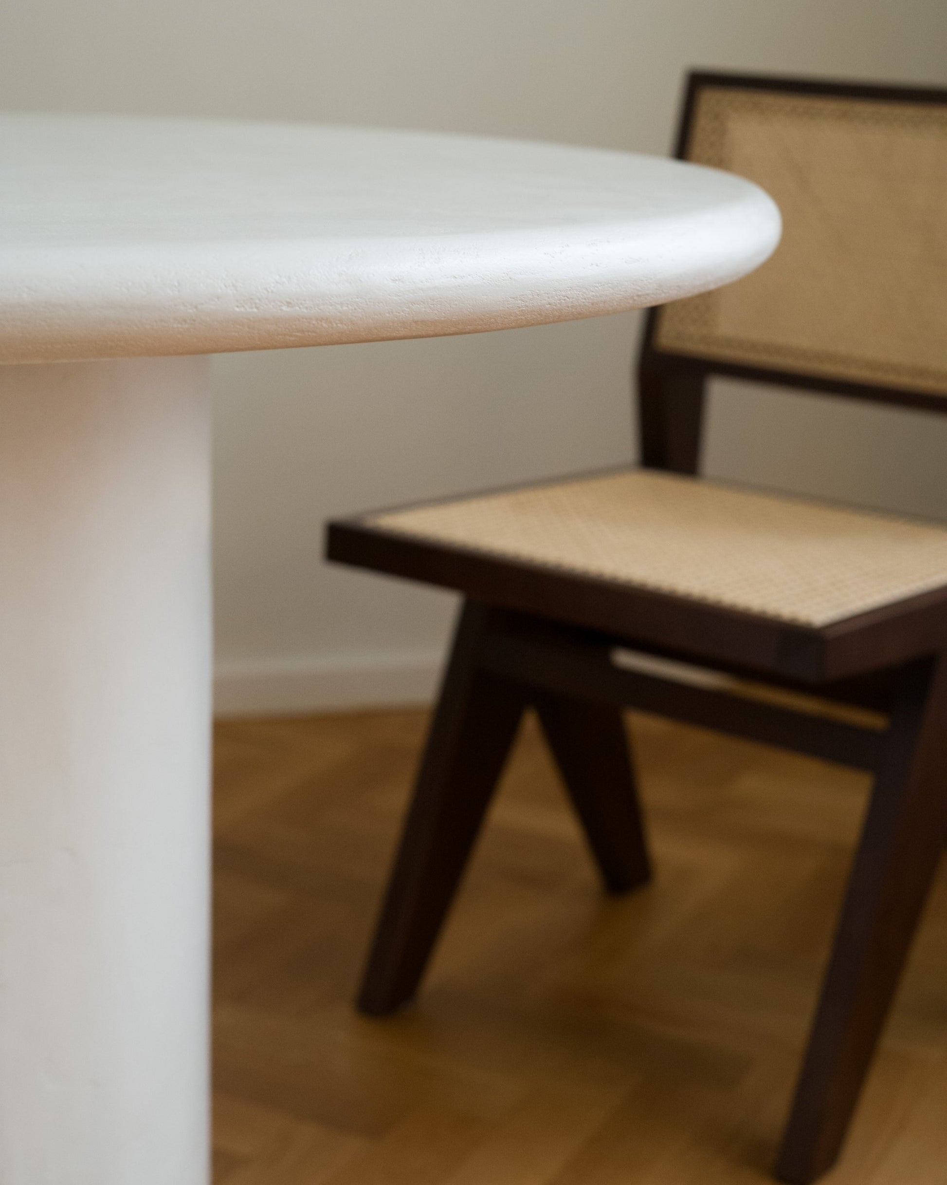 White Kanso Round dining table closeup with wooden chair