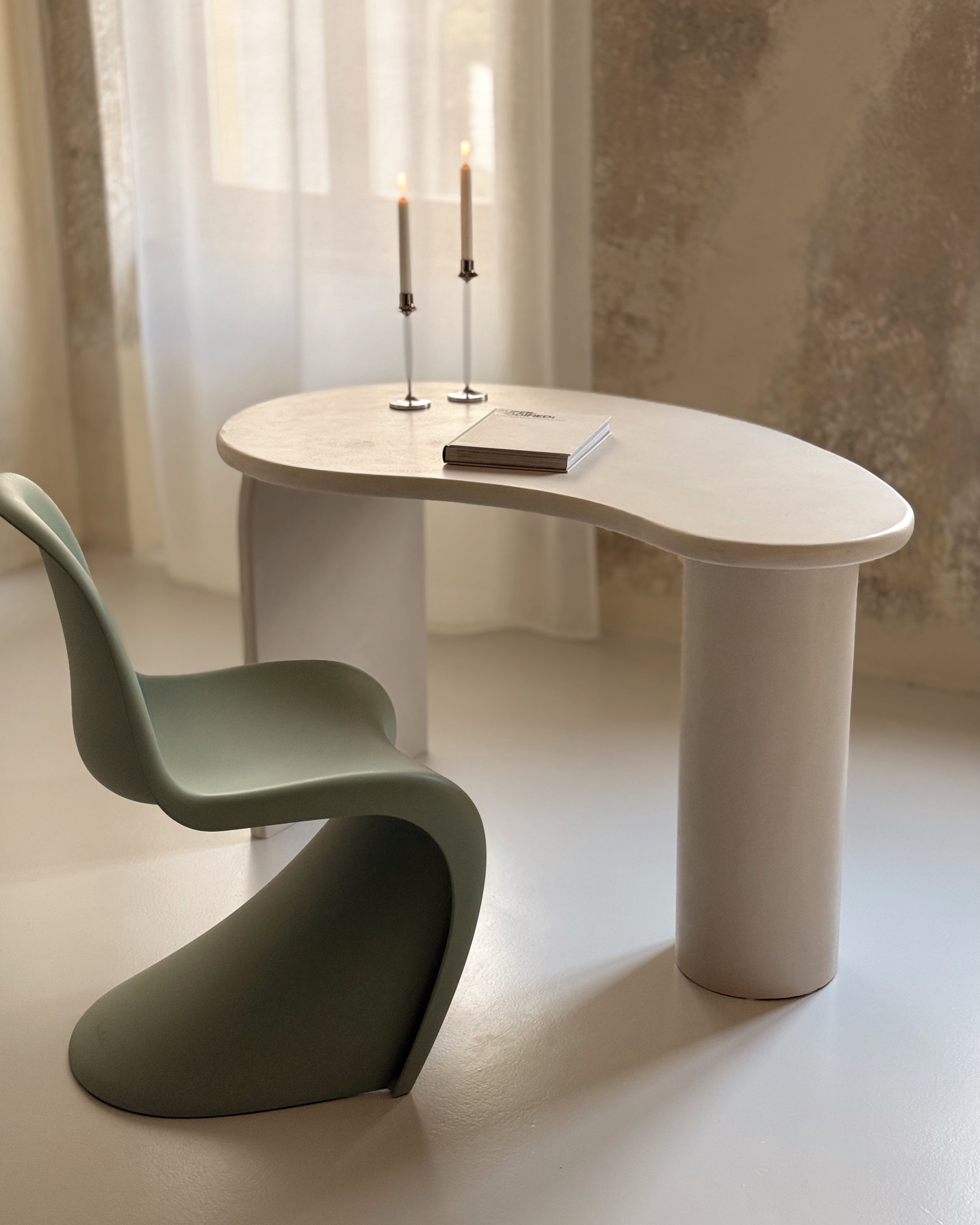 Kanso kidney-shaped microcement desk showing softly curved asymmetrical form