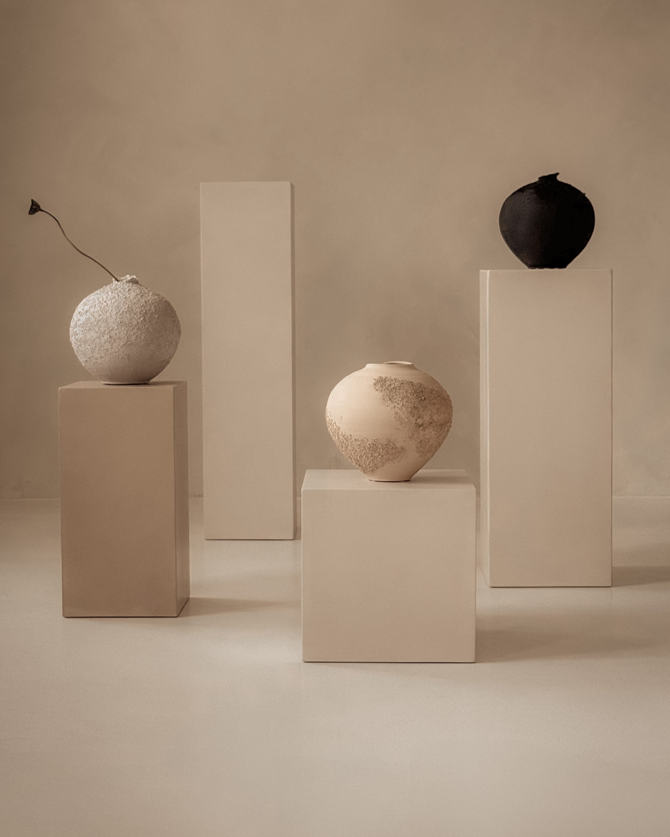 Group of microcement pedestals in various heights, sculptural gallery-like display
