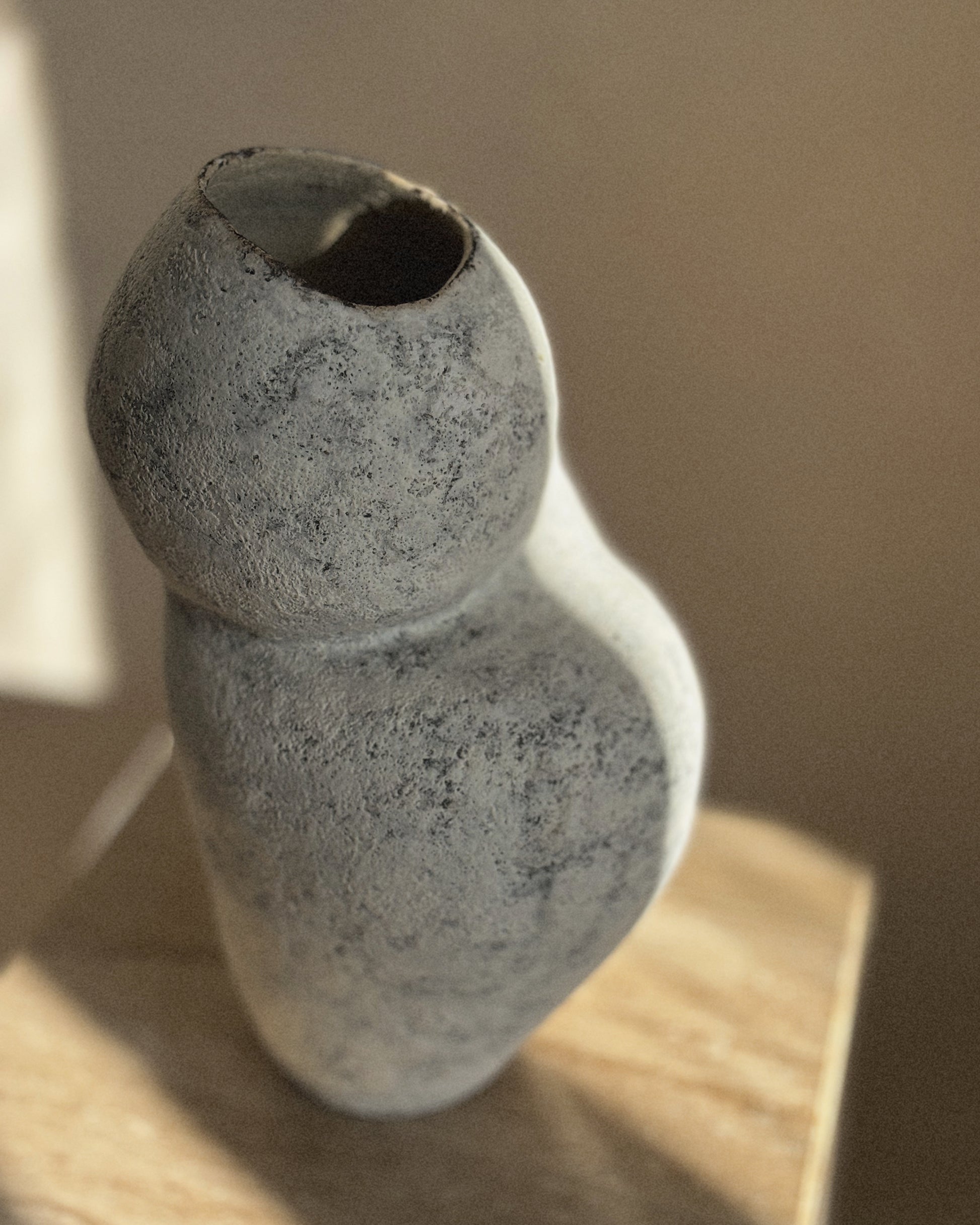 Li Ceramics sculptural grey vase placed in natural light with organic wabi-sabi form
