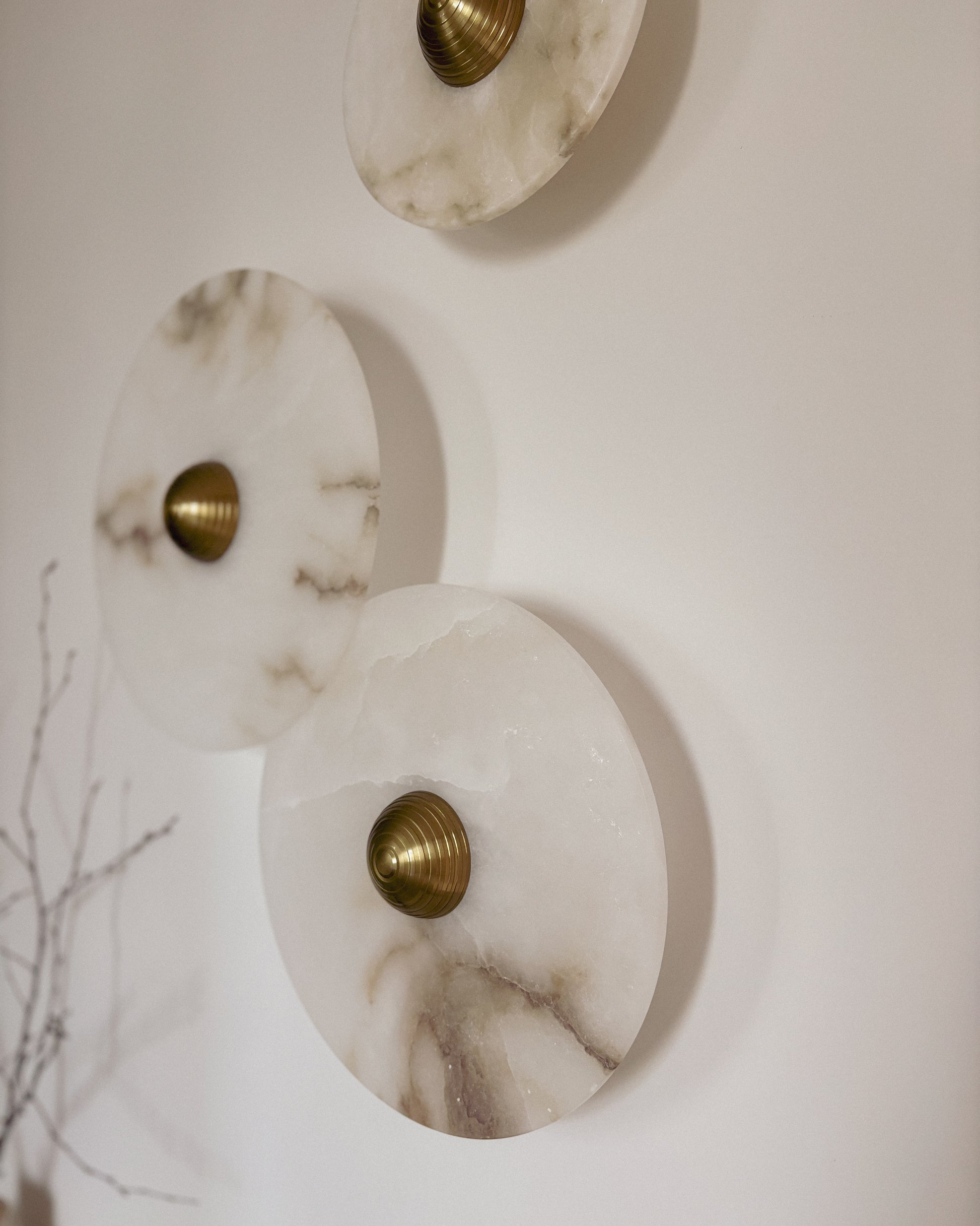 Close-up of marble wall light with brass fitting and organic stone texture
