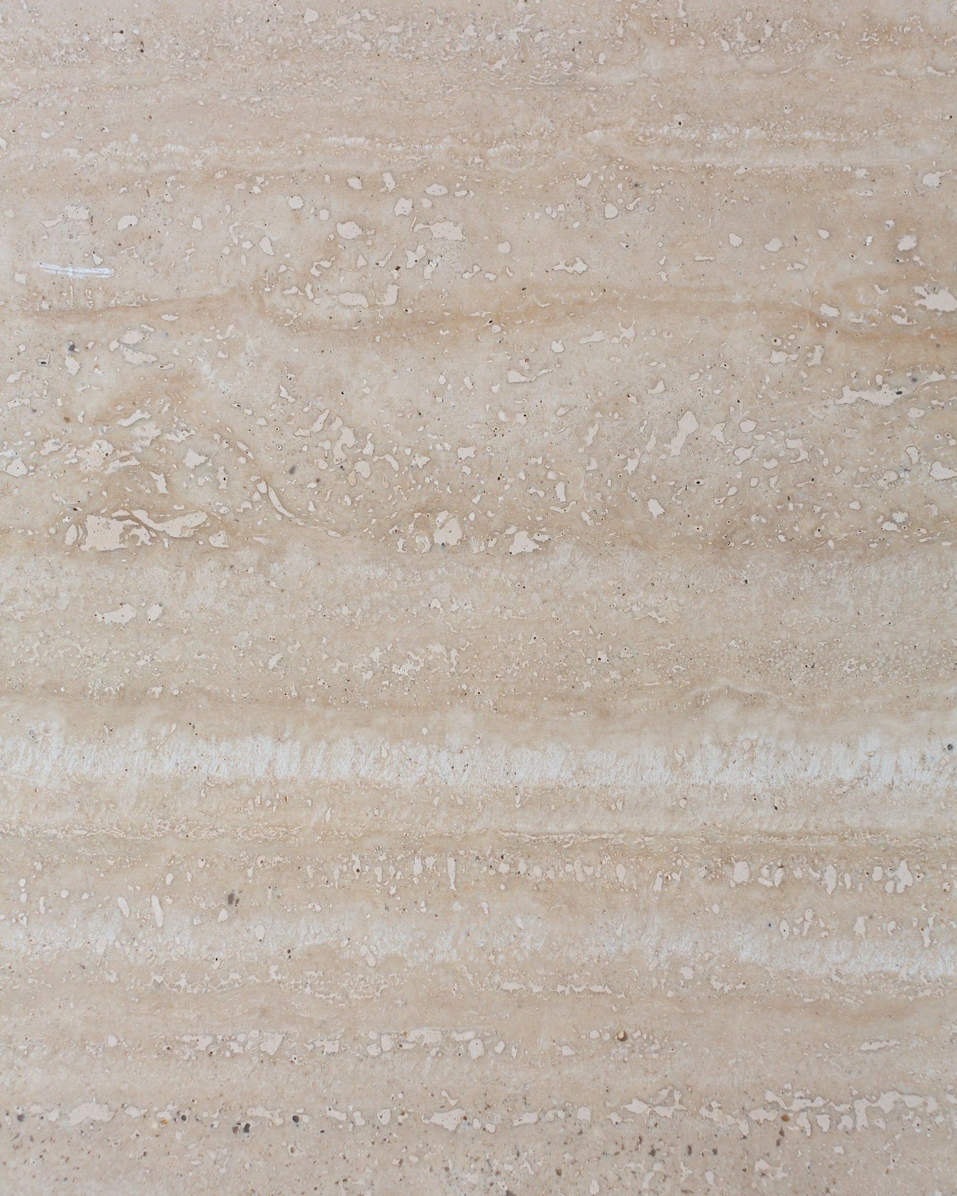 Close-up of travertine side table surface, natural beige stone texture